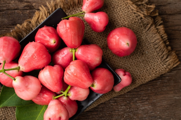 Manzana color de rosa rosada en la tabla de madera, fruta tropical asiática.