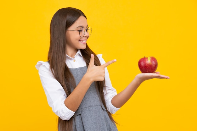 Manzana fresca Chica adolescente mantenga manzanas sobre fondo de estudio aislado amarillo Nutrición infantil Chica feliz cara emociones positivas y sonrientes