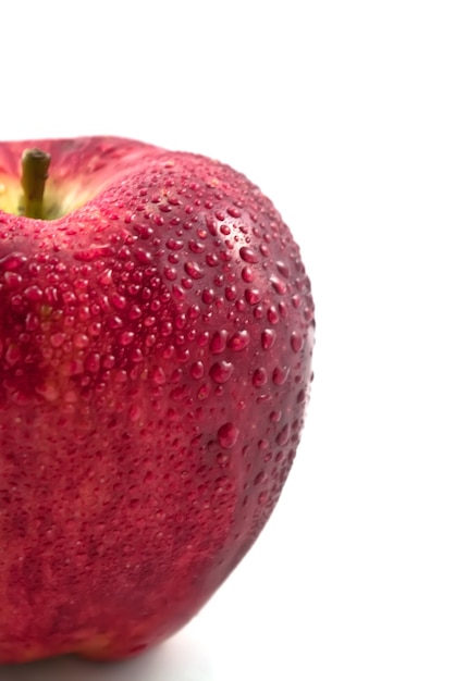 Manzana fresca con gotas de agua sobre el blanco