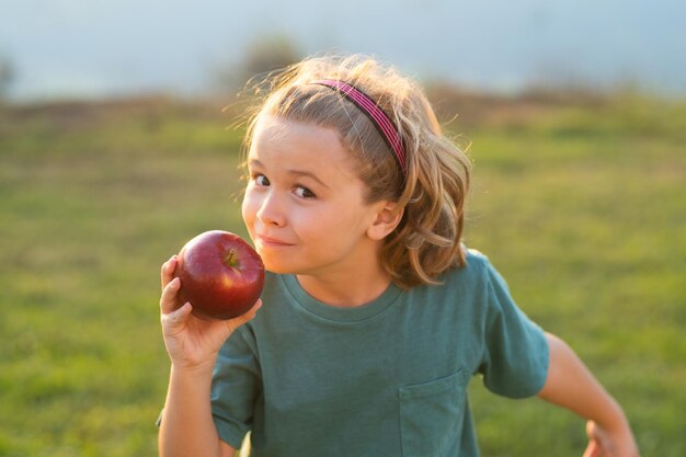 manzana fresca para niños niño con fondo de parque de verano de manzana niño comer manzana verde retrato de litt