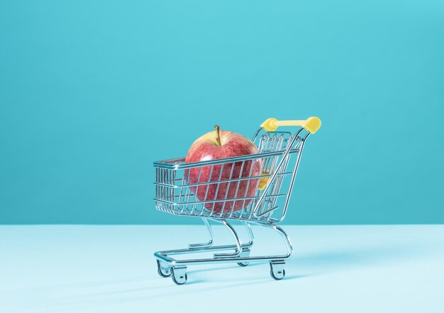 Manzana fresca en un pequeño carrito de supermercado