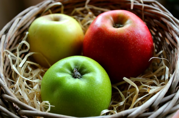 La manzana Gala, la manzana Granny Smith y la manzana Golden Delicious yacen una al lado de la otra en una cesta de mimbre