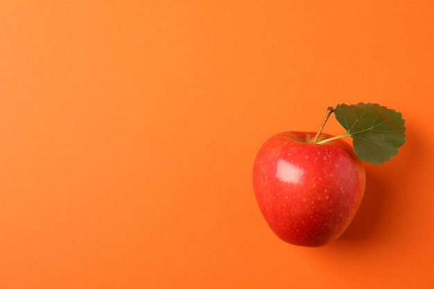 Foto manzana con hoja en mesa naranja