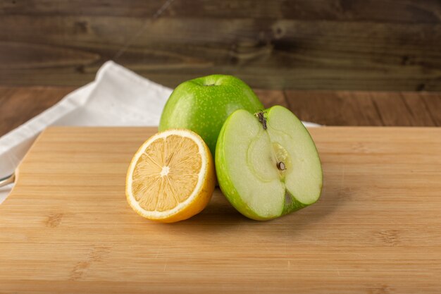 Manzana y limones en un tablero de madera