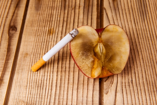 La manzana marchita y los cigarrillos representan una mala influencia.