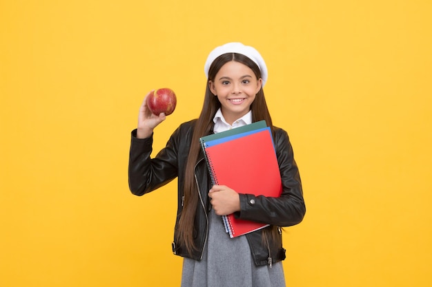 Manzana para la merienda escolar Niño en edad escolar con fondo amarillo de manzana Desayuno de regreso a la escuela Nutrición infantil Dieta saludable Alimentos vitamínicos Fruta que te hace más inteligente