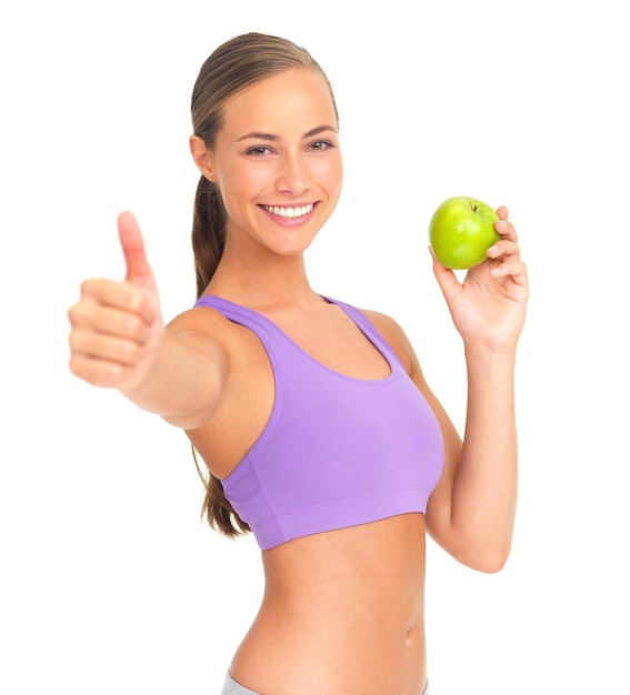 Manzana de mujer y pulgares hacia arriba en el retrato de estudio para la nutrición de la salud o el bienestar de fondo blanco Modelo aislado fruta saludable o sonrisa para el objetivo de la dieta vitamina c o desintoxicación natural para un cuerpo fuerte