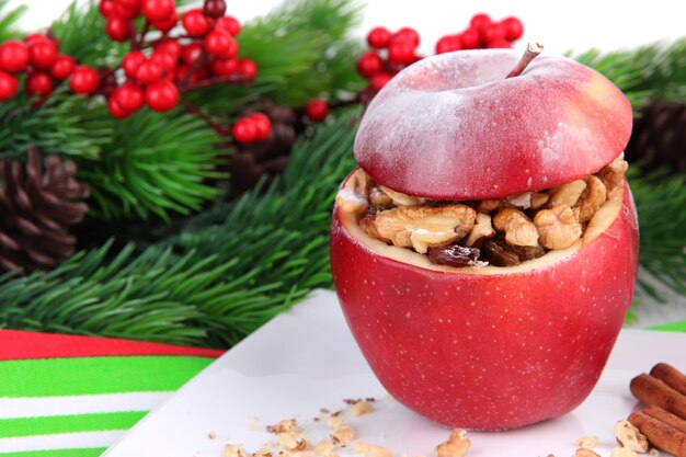 Manzana de Navidad rellena con nueces y pasas en la mesa de cerca