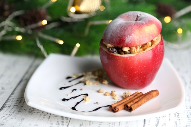 Manzana de Navidad rellena con nueces y pasas en la mesa de cerca