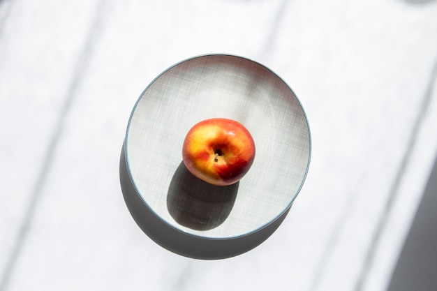 Una manzana en un plato sobre un fondo blanco Vista superior plana