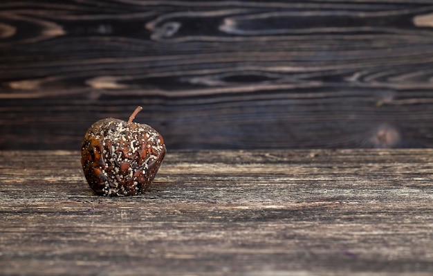 Manzana podrida en una pizarra de madera