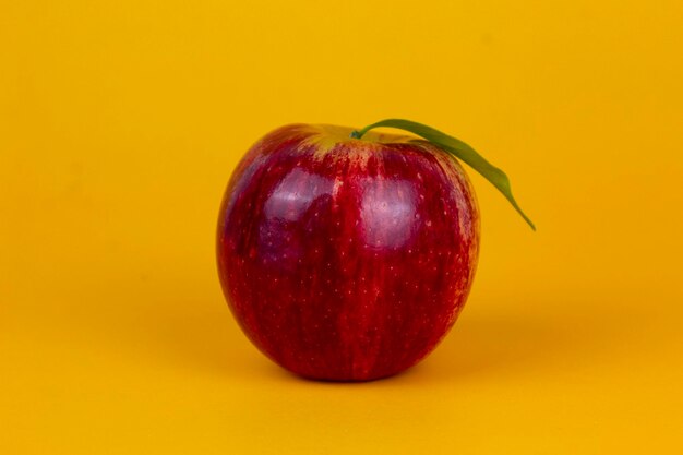 Una manzana roja aislada sobre fondo amarillo Fruta de manzana roja orgánica utilizada para el concepto de fruta saludable con trayectoria de corte y profundidad de campo completa