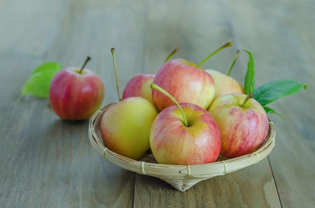 Manzana roja y amarilla sobre fondo de madera