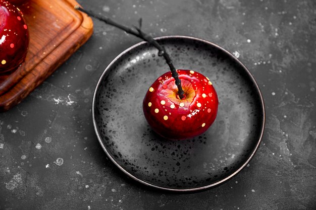 Manzana roja en caramelo con decoración de azúcar un regalo original para una mesa festiva de halloween