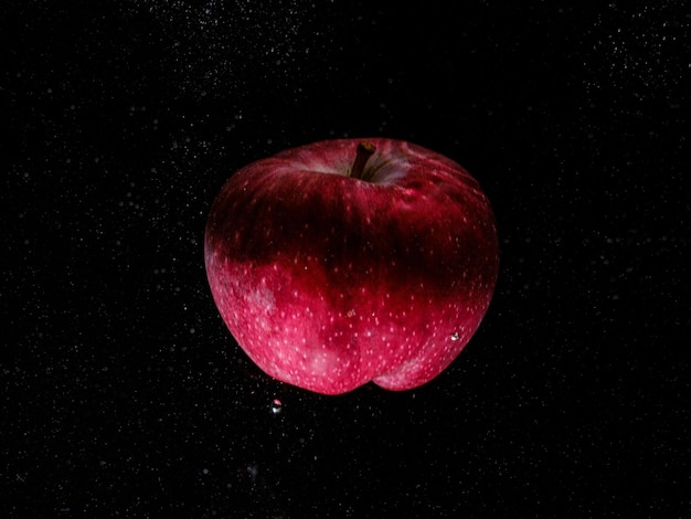 Manzana roja cayendo al agua