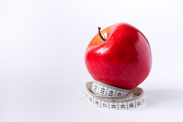 Manzana roja con cinta métrica