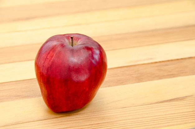 Manzana roja en el fondo de la mesa de madera