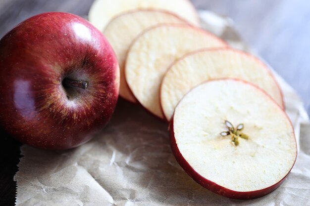 Manzana roja fresca en una mesa de cocina con textura de madera