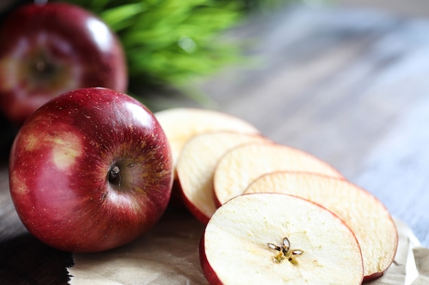 Manzana roja fresca en una mesa de cocina con textura de madera