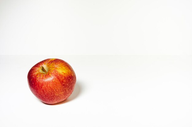 Una manzana roja fresca sobre un fondo blanco.