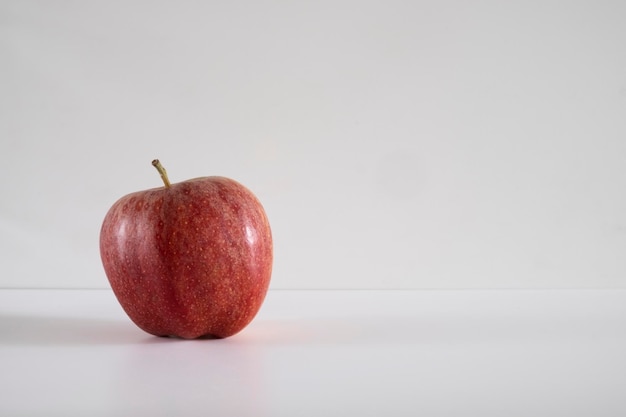 Una manzana roja fresca sobre un fondo blanco.