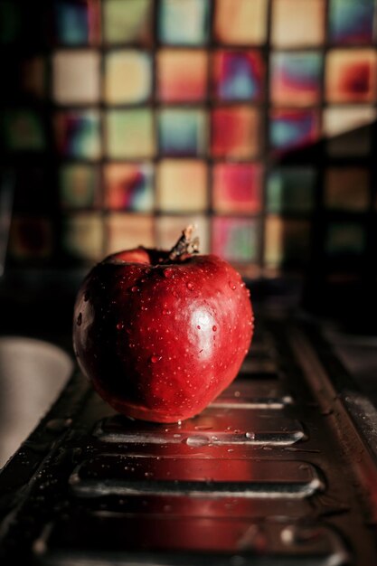 Manzana roja en gotas de agua en la cocina