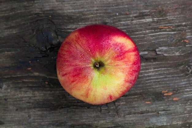 Manzana roja con gotas de agua sobre la vieja mesa de grunge