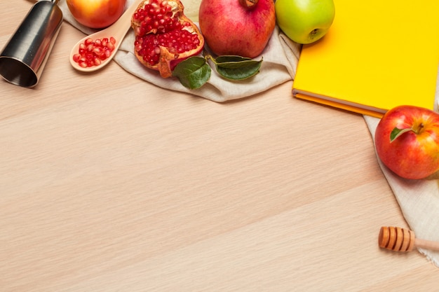 Manzana roja, granada y tarro de miel para el año nuevo judío sobre tabla de madera