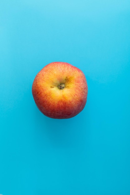 Manzana roja jugosa sobre fondo azul tema comida tiro