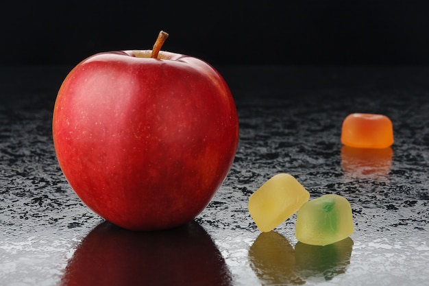 Foto manzana roja y mermelada sobre negro