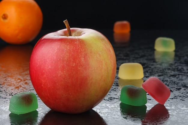 Foto manzana roja y mermelada sobre negro