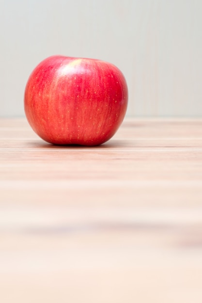 Una manzana roja en la mesa de madera