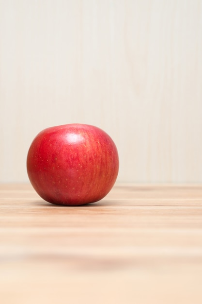 Una manzana roja en la mesa de madera