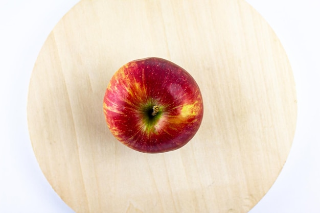 Manzana roja natural en un plato de madera Manzana roja fresca en un plato de madera