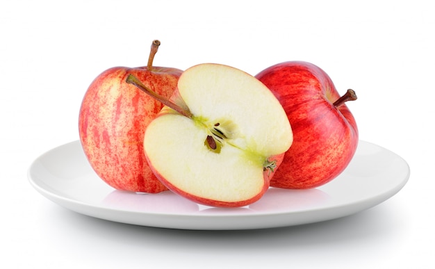 Foto manzana roja en un plato aislado sobre un fondo blanco.