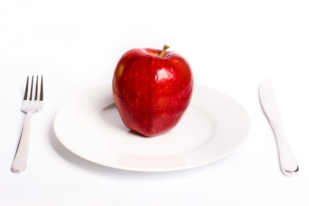 Manzana roja en plato blanco