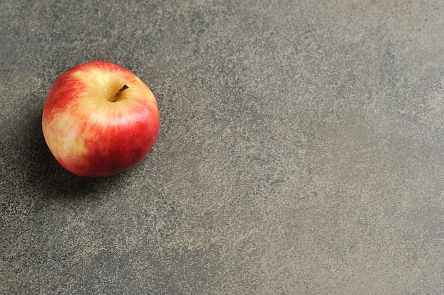 Manzana roja sobre un fondo gris - vista superior