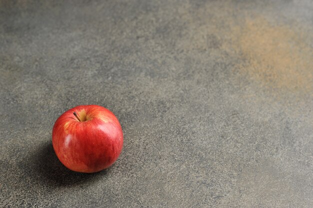 Manzana roja sobre un fondo gris - vista superior