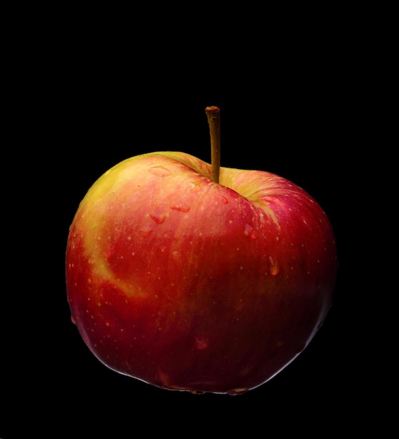 Manzana roja sobre un fondo negro neutro.