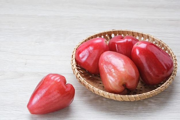 Manzana rosada (Jambu Air) en plato de bambú, fruta tropical.