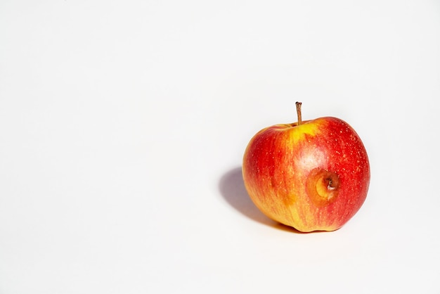Manzana sobre un fondo blanco Comida feaEl lado estropeado de la manzana comenzó a pudrirse Alimentos sin transgénicos Copiar espacio