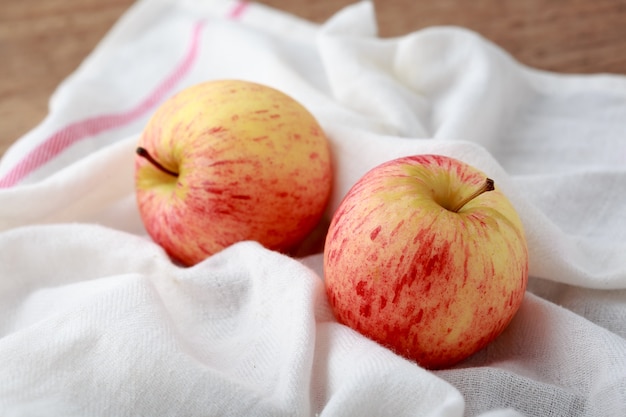 manzana con tela blanca en la mesa de madera