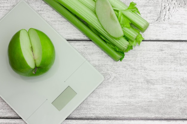 Manzana verde con apio en la balanza Comida vegetariana