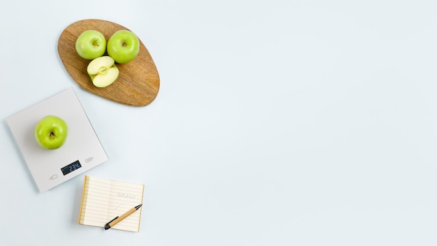 Manzana verde en báscula de cocina digital gris Cerca del bloc de notas con número de calorías Espacio de copia plana