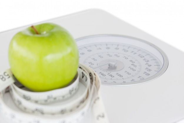 Manzana verde en un círculo con una cinta métrica y balanza