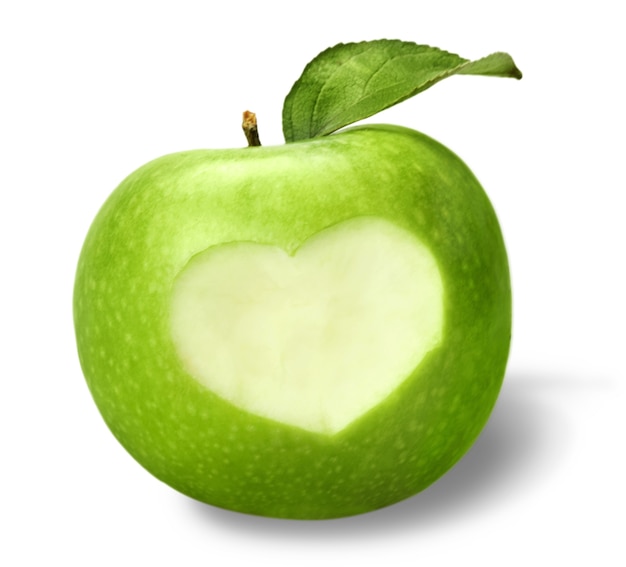 Manzana verde con corazón cortado y hojas, aisladas