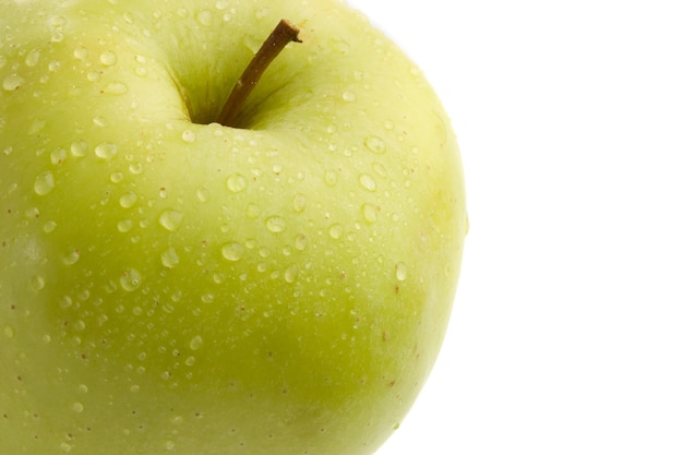 Manzana verde deliciosa con gotas de agua sobre un fondo blanco