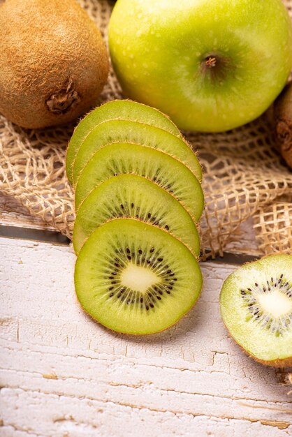 Manzana verde y kiwi manzanas verdes y kiwi sobre madera rústica con enfoque selectivo de tela rústica