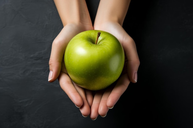 Manzana verde en la mano de una mujer sobre un fondo gris Dieta para perder peso