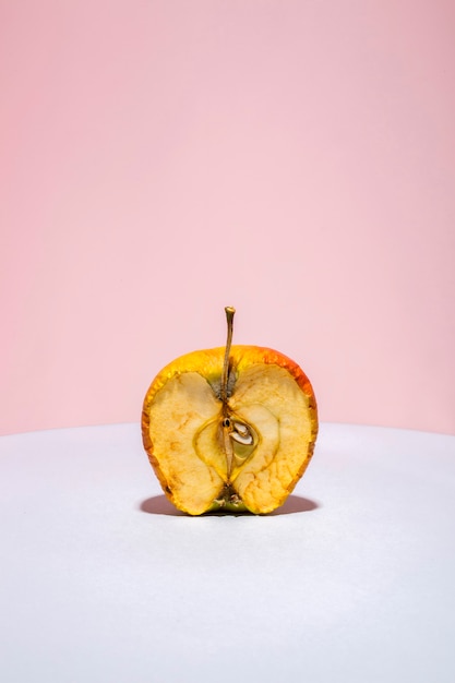 Manzana vieja en un corte sobre un fondo coloreado